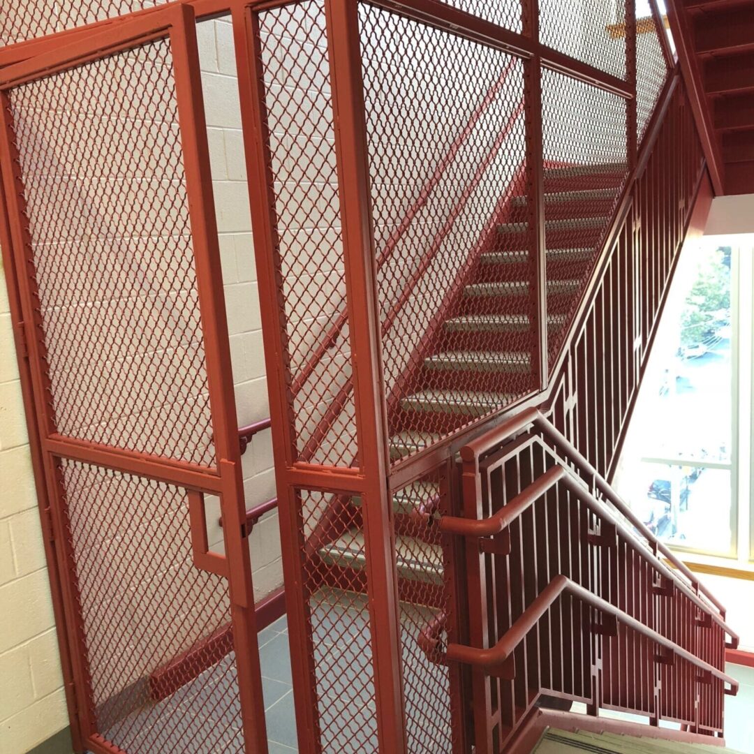 A staircase with metal railing and wood handrail.