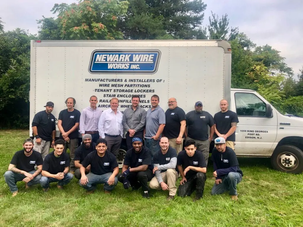 A group of people standing in front of a truck.