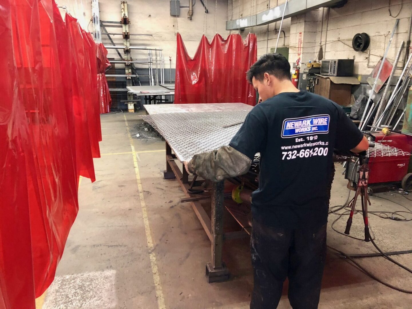 A man working in a factory with red curtains