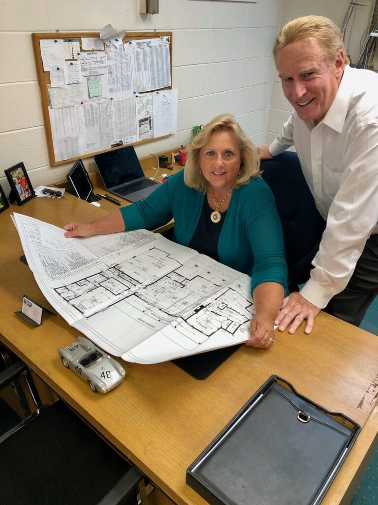 A man and woman are standing at the desk