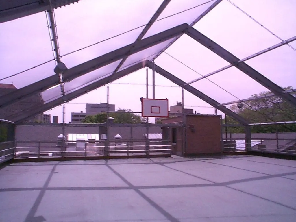 A basketball court with a net and a basket ball hoop.