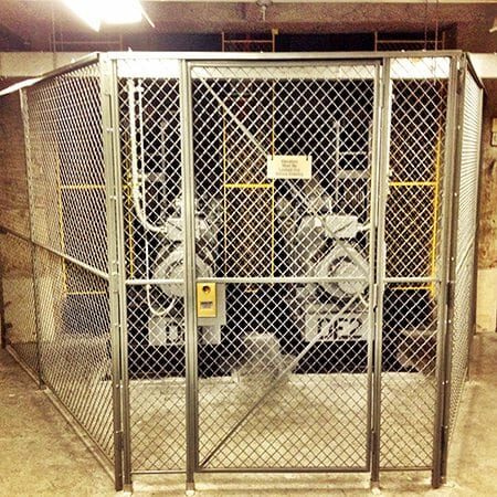 A chain link fence with two machines in it.